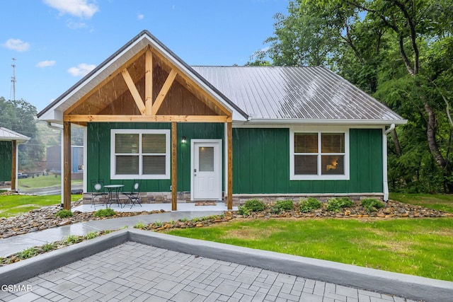 1010 Pinyon Cir, Pigeon Forge, TN 37863 - view of front of house featuring board and batten siding, a front yard, and a metal roof