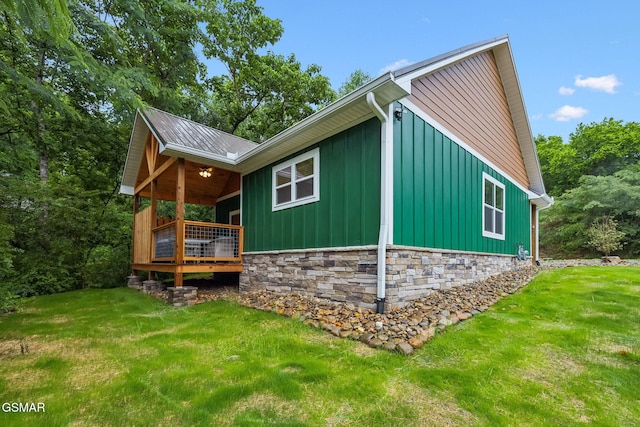 1010 Pinyon Cir, Pigeon Forge, TN 37863 - view of side of property with board and batten siding, a yard, and stone siding