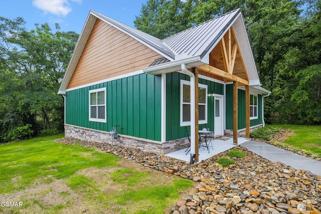 1010 Pinyon Cir, Pigeon Forge, TN 37863 - view of home's exterior featuring board and batten siding, a patio area, a standing seam roof, and a yard