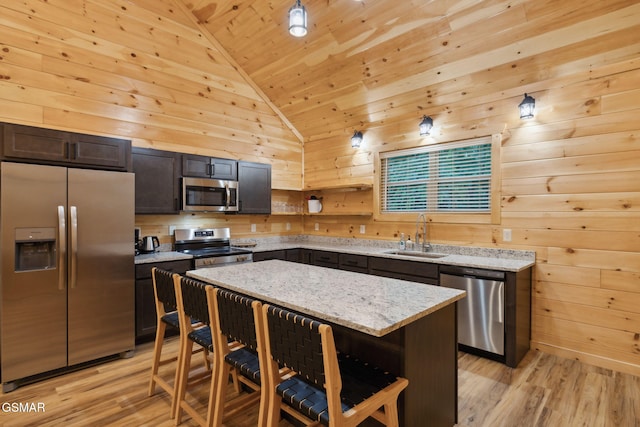 1010 Pinyon Cir, Pigeon Forge, TN 37863 - kitchen featuring stainless steel appliances, wooden walls, wooden ceiling, a breakfast bar area, and light wood finished floors