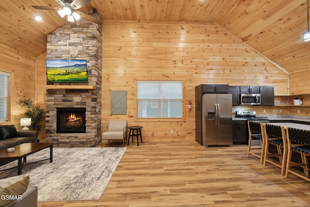 1010 Pinyon Cir, Pigeon Forge, TN 37863 - living area featuring wooden ceiling, high vaulted ceiling, wood walls, a ceiling fan, and a stone fireplace