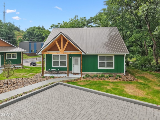 1010 Pinyon Cir, Pigeon Forge, TN 37863 - view of front of house with a metal roof, a front lawn, board and batten siding, and covered porch