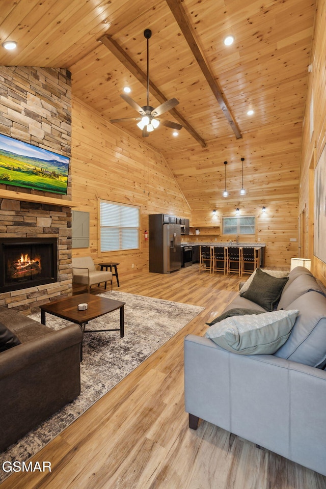 1010 Pinyon Cir, Pigeon Forge, TN 37863 - living room featuring a wooden ceiling with exposed beams, wooden walls, a fireplace, a ceiling fan, and wood finished floors