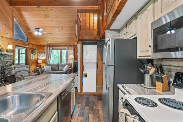 1514 Ridgecrest Dr, Sevierville, TN 37876 - kitchen featuring appliances with stainless steel finishes, stacked washer / drying machine, a ceiling fan, dark wood-style flooring, and wooden walls