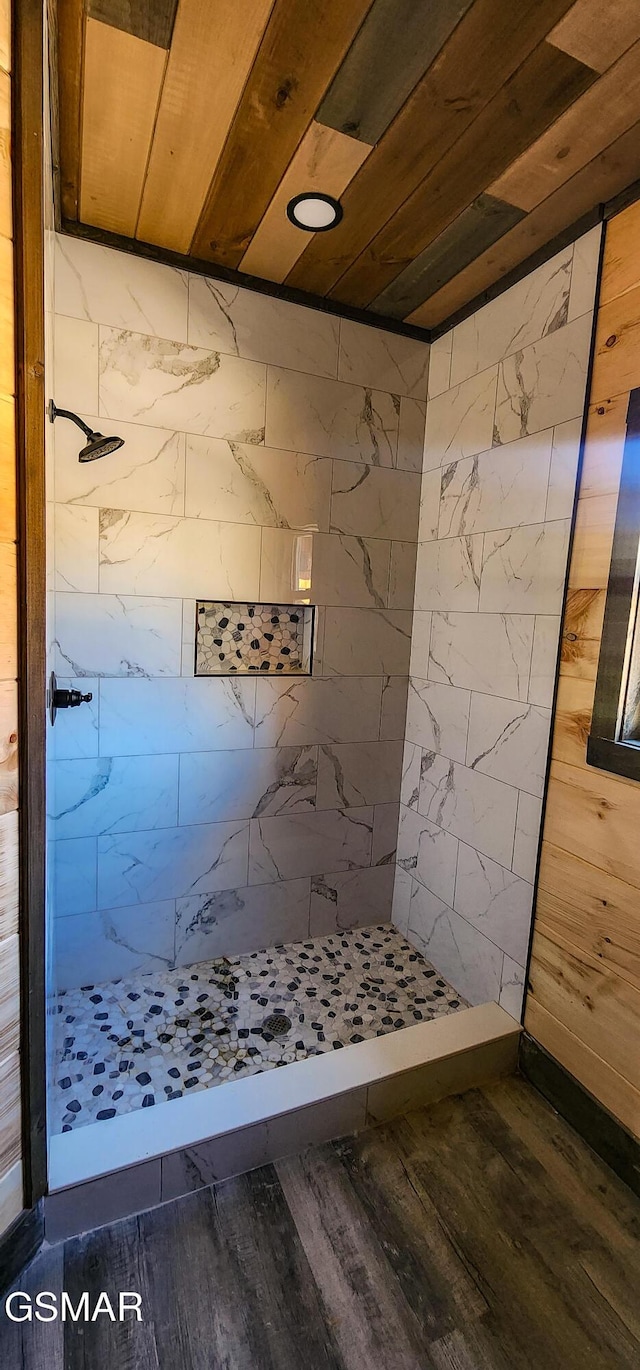 full bathroom featuring wood ceiling, wood finished floors, and a tile shower