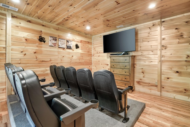 cinema room featuring wood walls, wood ceiling, and light hardwood / wood-style floors