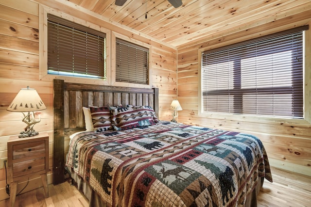 bedroom featuring wood walls, ceiling fan, wood ceiling, and light wood-type flooring