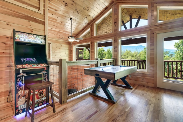 playroom with wood ceiling, ceiling fan, wooden walls, high vaulted ceiling, and hardwood / wood-style floors