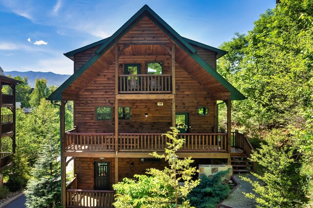 back of house with a mountain view and a balcony