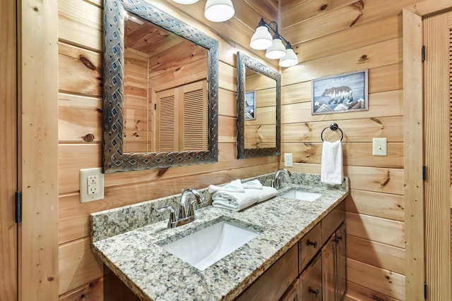 bathroom featuring vanity and wooden walls