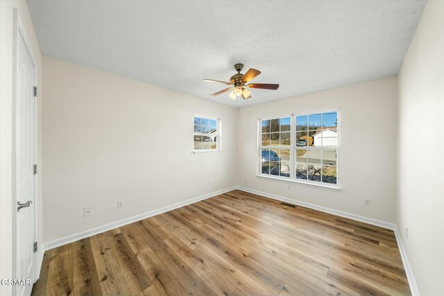 spare room with ceiling fan, hardwood / wood-style floors, and a textured ceiling