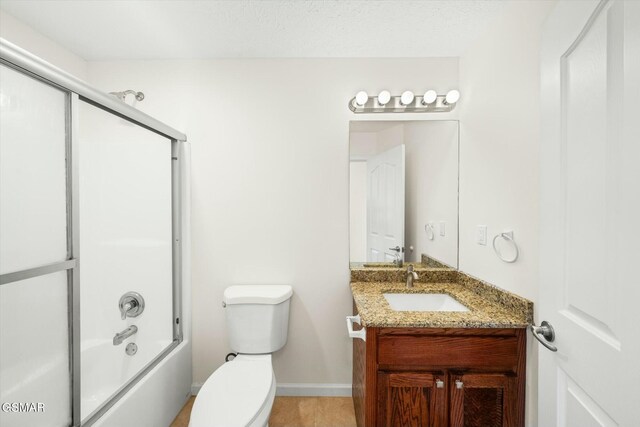 full bathroom with vanity, bath / shower combo with glass door, a textured ceiling, and toilet