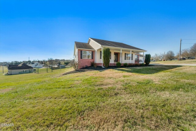 single story home featuring covered porch and a front lawn