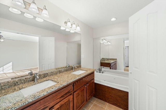 bathroom featuring tile patterned floors, vanity, ceiling fan, and a washtub