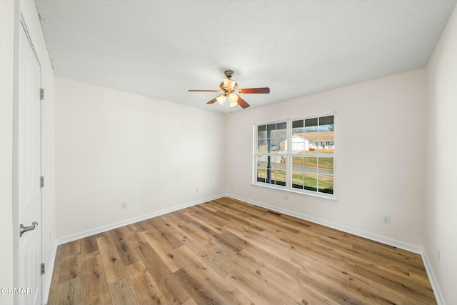 empty room featuring ceiling fan, light hardwood / wood-style floors, and a textured ceiling