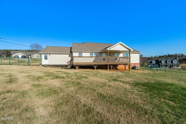 back of property with a yard, cooling unit, and a wooden deck