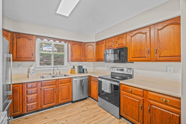526 Briarcliff Way Apt 102, Pigeon Forge, TN 37863 - kitchen featuring stainless steel appliances, brown cabinetry, light wood-type flooring, and light countertops