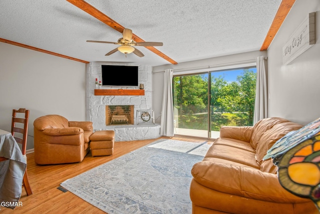 526 Briarcliff Way Apt 102, Pigeon Forge, TN 37863 - living room with a ceiling fan, a stone fireplace, a textured ceiling, and wood finished floors