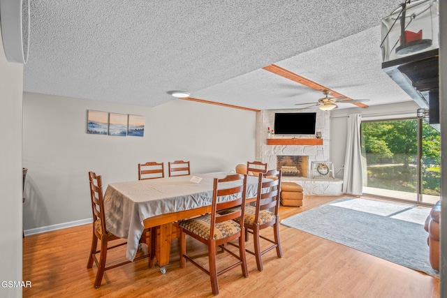 526 Briarcliff Way Apt 102, Pigeon Forge, TN 37863 - dining room with a ceiling fan, a textured ceiling, light wood finished floors, and a fireplace