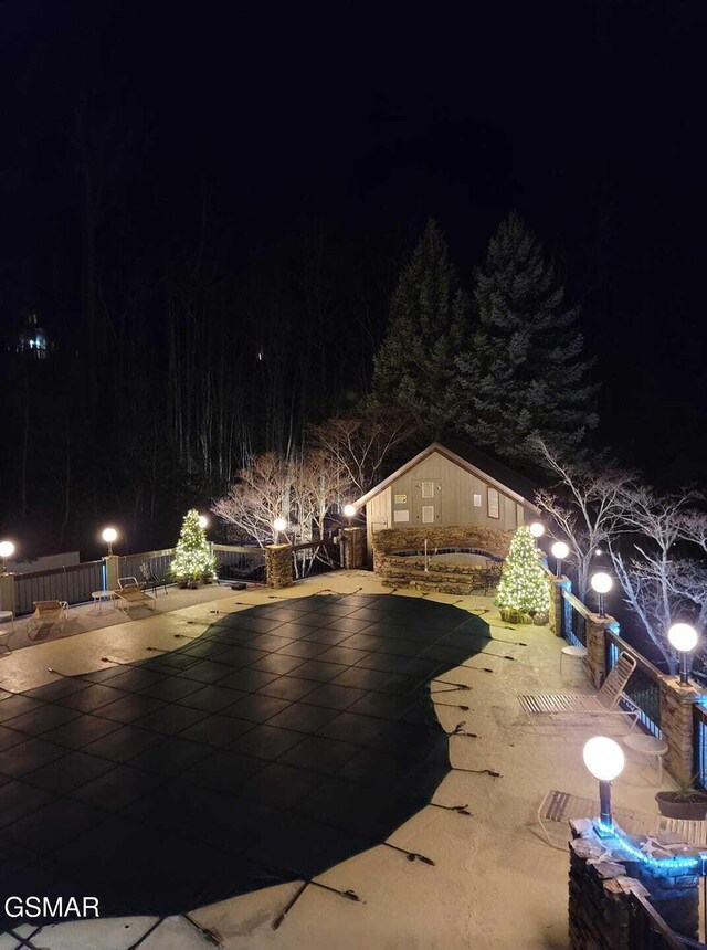 pool at twilight with a patio area