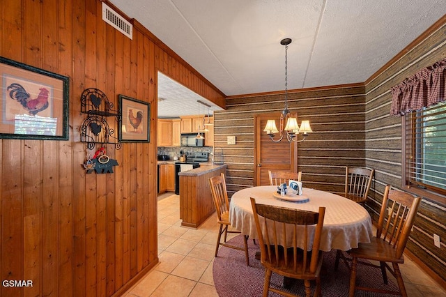 dining area with a notable chandelier, wood walls, and light tile patterned floors