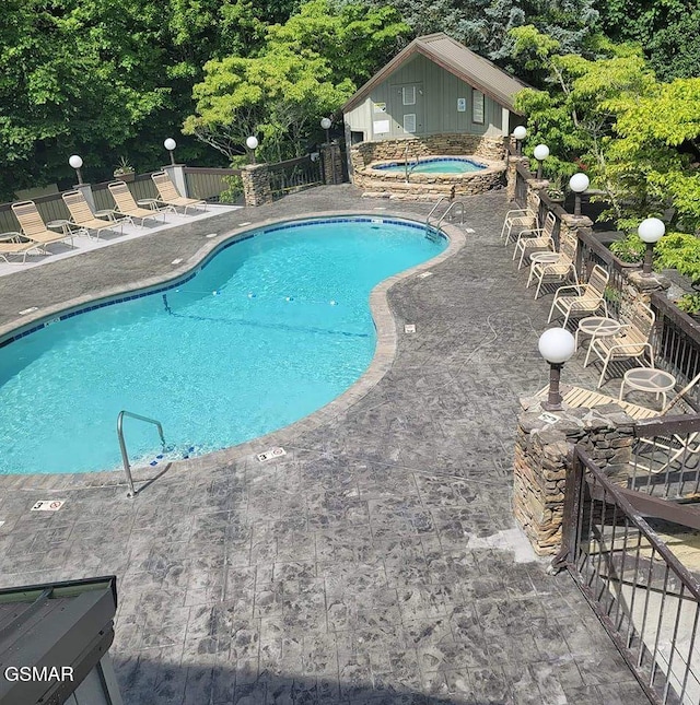 view of pool with a patio area and a community hot tub