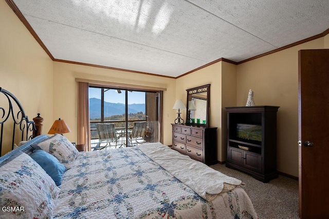 bedroom featuring carpet flooring, a mountain view, a textured ceiling, and access to outside