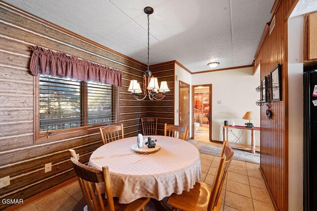 dining space featuring wood walls, light tile patterned flooring, crown molding, and a chandelier