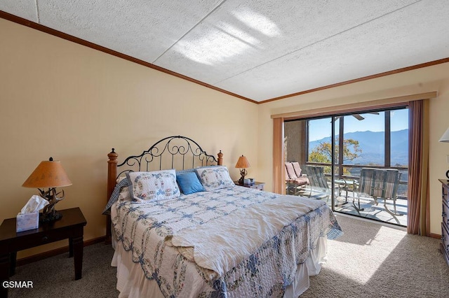 bedroom featuring a mountain view, a textured ceiling, carpet floors, and access to outside