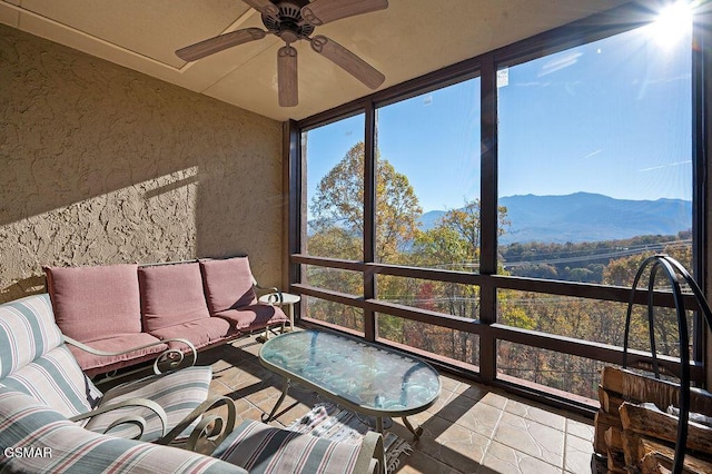 sunroom featuring a mountain view and ceiling fan