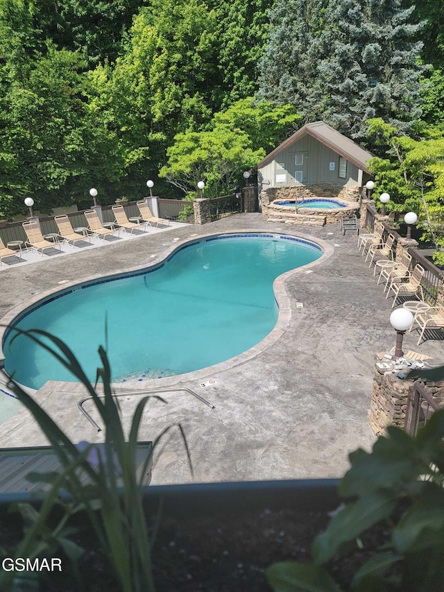 view of pool featuring a community hot tub and a patio