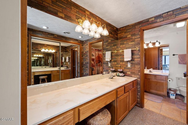 bathroom featuring vanity, a textured ceiling, tile patterned floors, and toilet