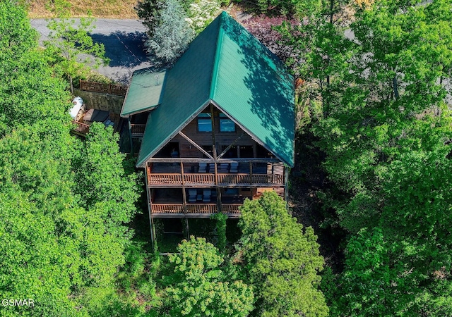 back of house featuring a balcony and metal roof