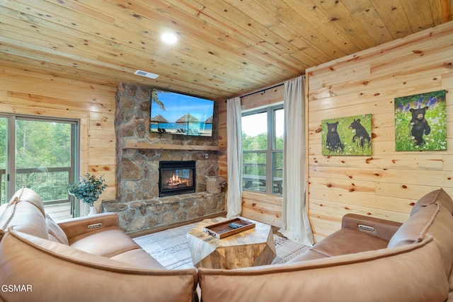 living room with wood-type flooring, wooden ceiling, a fireplace, and wooden walls