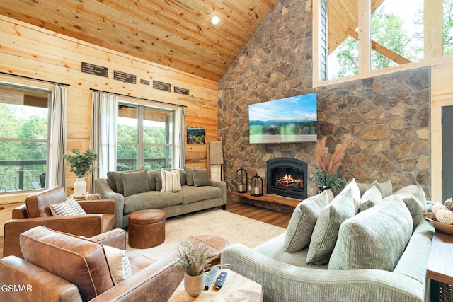 living room featuring a fireplace, hardwood / wood-style flooring, high vaulted ceiling, and wood walls