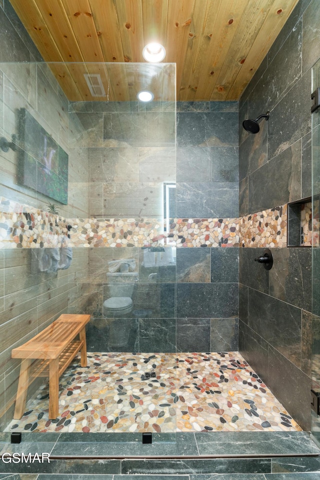 bathroom featuring wooden ceiling and tiled shower