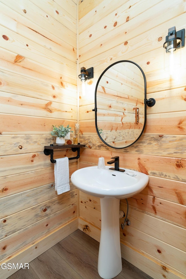 bathroom featuring hardwood / wood-style flooring and wood walls