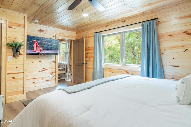 bedroom with ceiling fan, wooden walls, wood ceiling, and hardwood / wood-style flooring