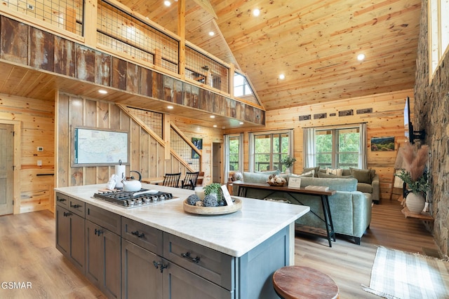 kitchen with light hardwood / wood-style flooring, high vaulted ceiling, stainless steel gas cooktop, and wooden ceiling