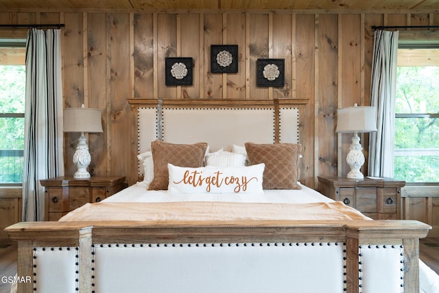 unfurnished bedroom featuring multiple windows, wooden ceiling, and wood walls