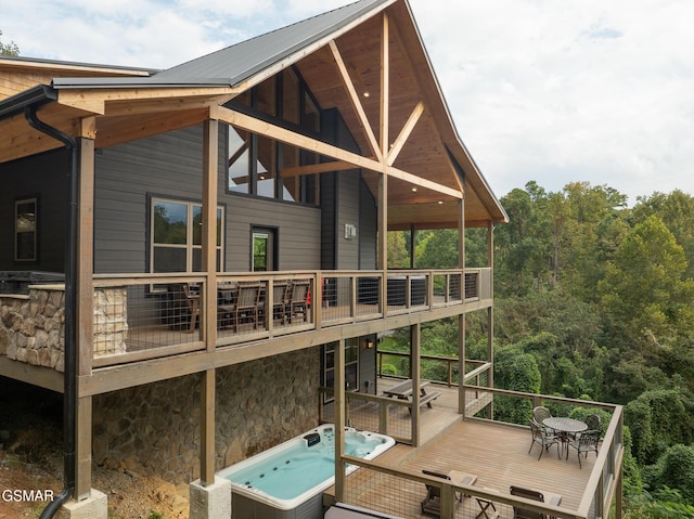 back of house featuring a hot tub and a wooden deck