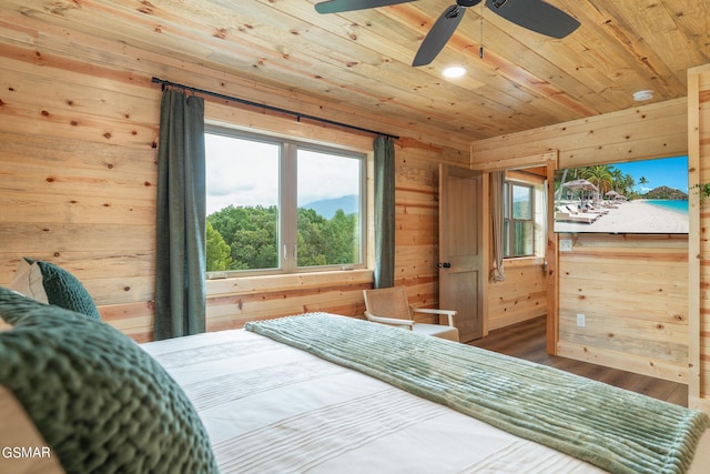 bedroom featuring hardwood / wood-style flooring, ceiling fan, wood walls, and wood ceiling