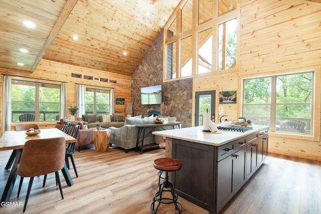 kitchen featuring wooden ceiling, a kitchen island with sink, high vaulted ceiling, light hardwood / wood-style flooring, and beamed ceiling