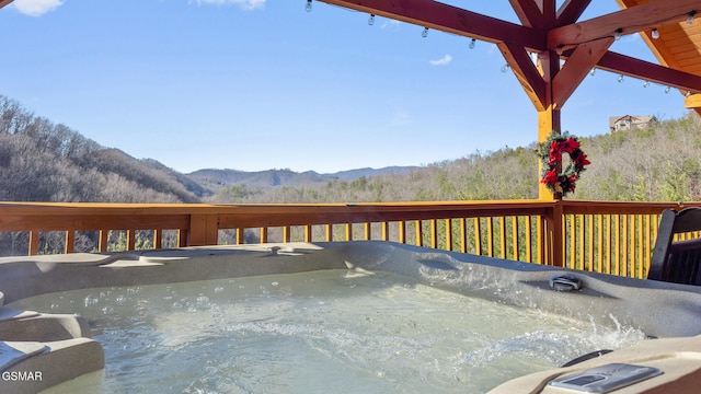 deck with a mountain view and a hot tub