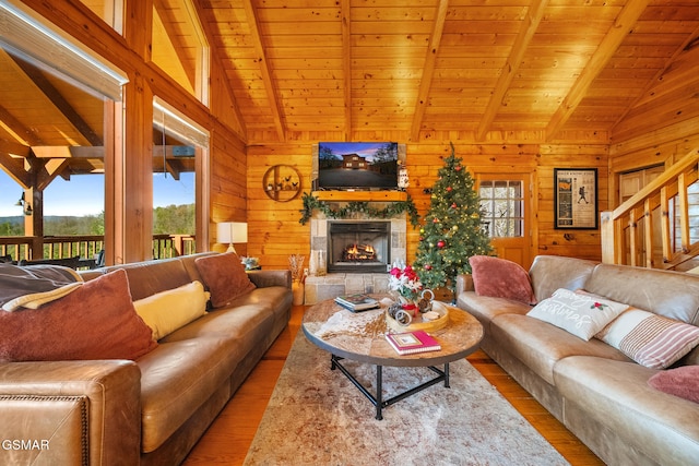 living room featuring beamed ceiling, wood walls, and wood ceiling