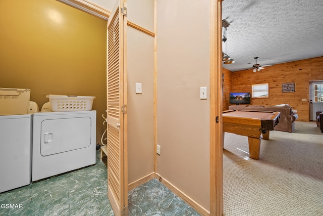 laundry room featuring a textured ceiling, ceiling fan, wooden walls, separate washer and dryer, and pool table