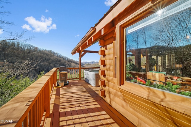 wooden deck featuring a mountain view and a grill