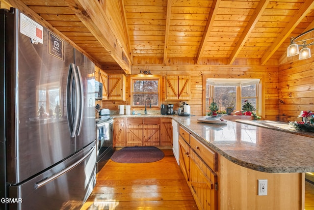 kitchen with wood ceiling, wooden walls, sink, and stainless steel appliances