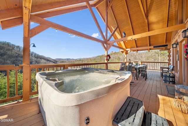 wooden deck featuring a mountain view and an outdoor hot tub