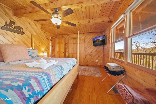 bedroom featuring wood walls, ceiling fan, beam ceiling, wood-type flooring, and wood ceiling